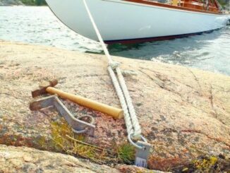 Förtöjningslina och bergkil säkrar en båt vid skärgårdsklippa